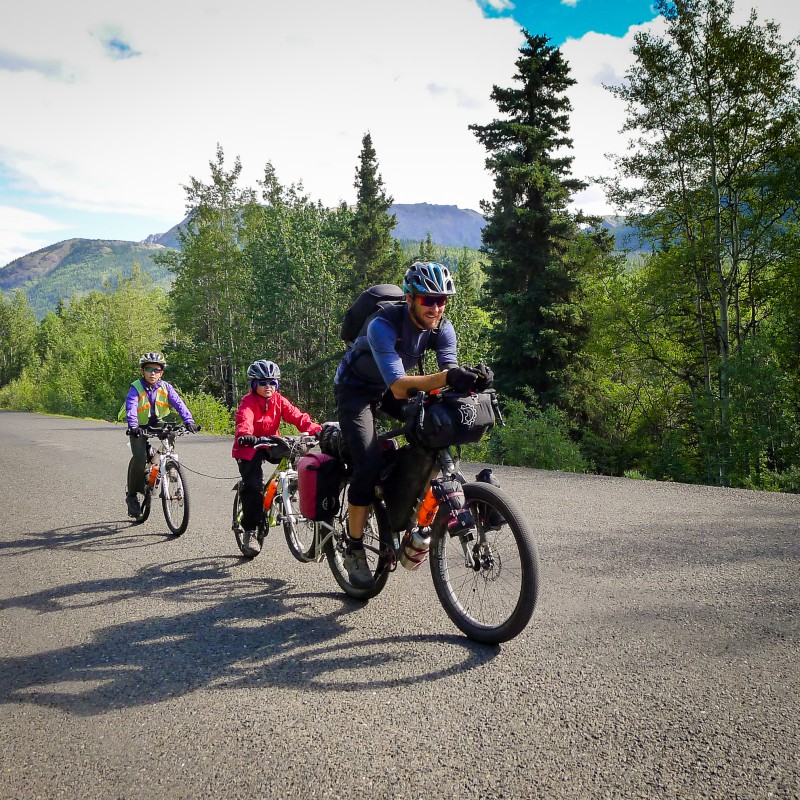 With kids attached, dad’s train rolls at 15 mph on the flats and they pull back-to-back 60+ mile days.