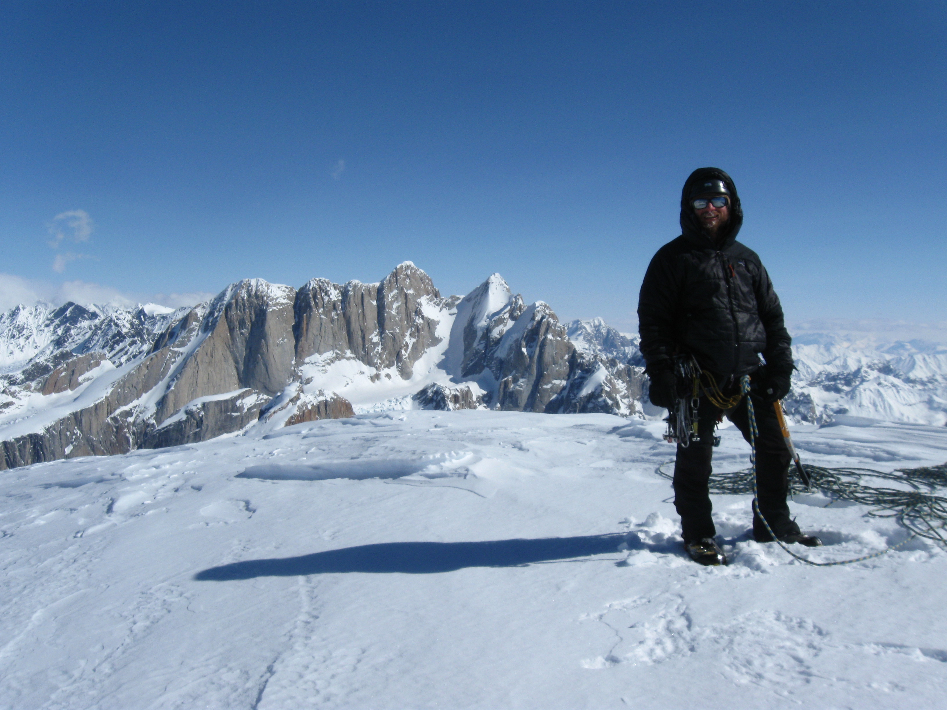 Eroh on the summit of Mt. Bradley after the first accent of Neve Ruse, with the Moose's Tooth in the background.