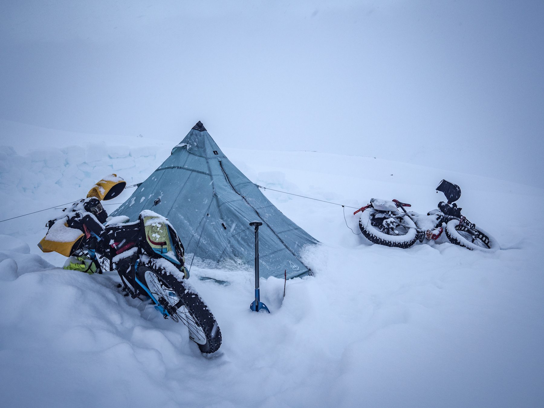 "The next morning was a welcome sight, of sorts. It had stopped snowing, but the trail (and our camp) was drifted in, and more snow threatened. The everyday chores of camp life become much harder work in winter, and the snow only added to that workload. The worst thing was when the frosted breath on the rim of my sleeping bag fell down my nose in the night! The skiers in nearby huts seemed to be taking a day off, so no fresh tracks to follow meant that we would be breaking trail for the day." ~Huw Oliver