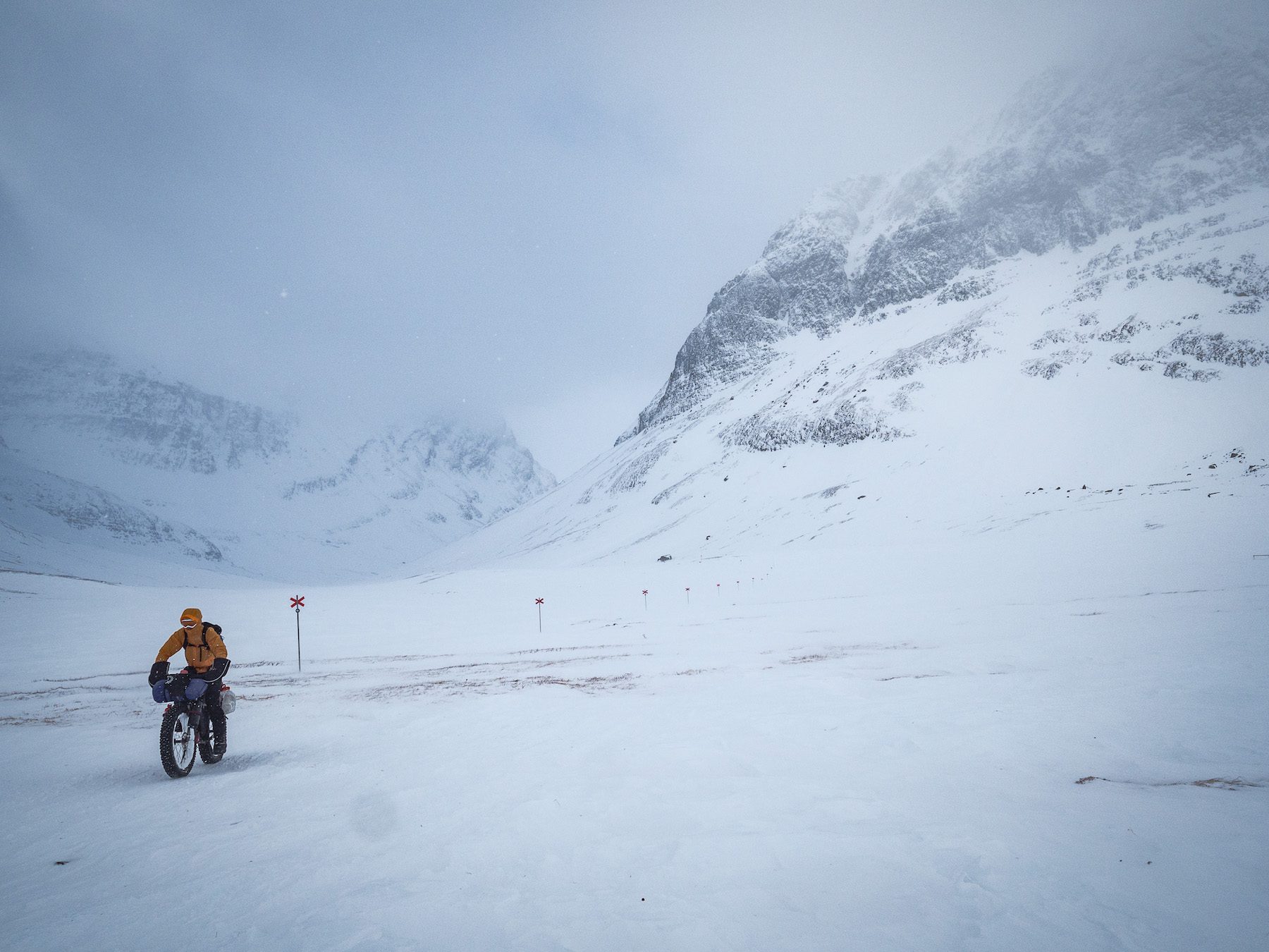 "We took this photo on one of the best days riding I’ve ever had. The trail took us over a final pass, the wind pushing us uncontrollably forwards. As the valley narrowed, huge dark cliffs loomed in the mist, surrounding a rollercoaster descent as we fishtailed through the soft snow. Being enveloped by huge mountains made us feel very small and reminded us what a privilege it was to be able to move through such an amazing landscape." ~Annie Le Evans